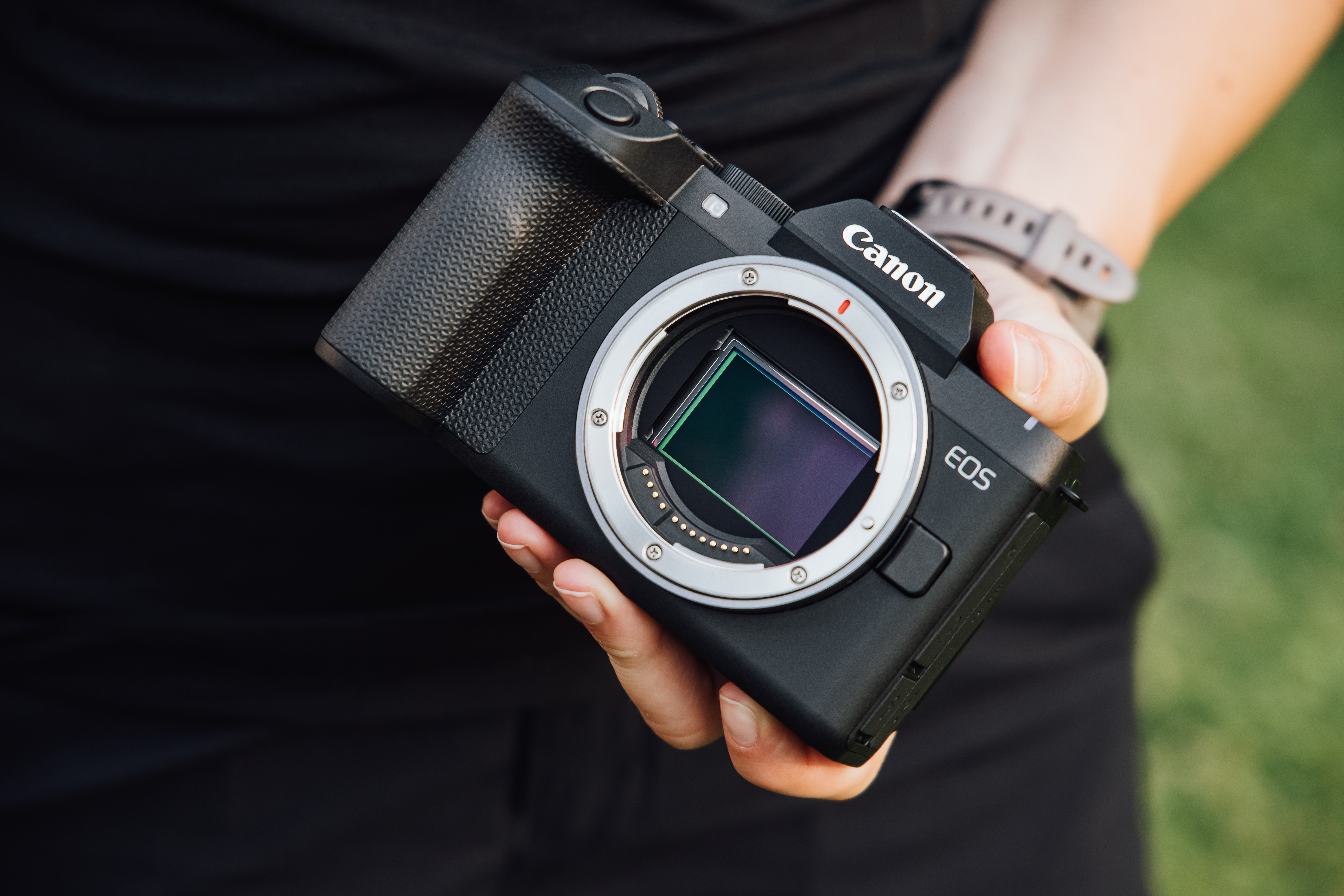 A hand holding a camera